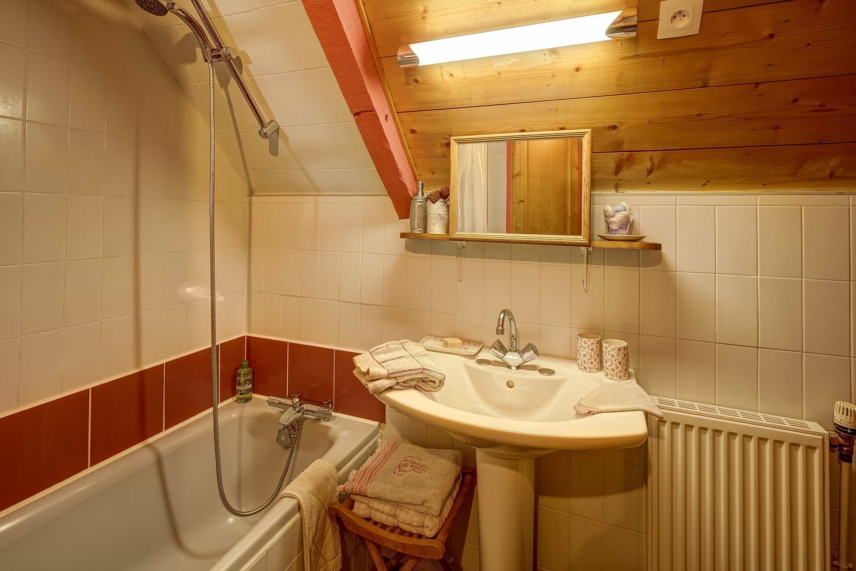 Un baño con bañera, lavabo y espejo.