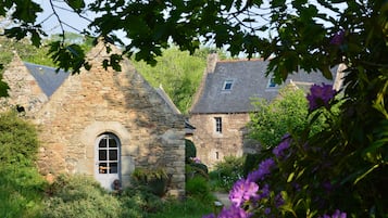 Experience the serene charm of this rustic cottage, nestled among lush gardens and traditional architecture.