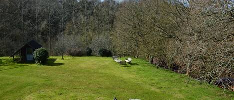 A grassy area with benches and a small shed.