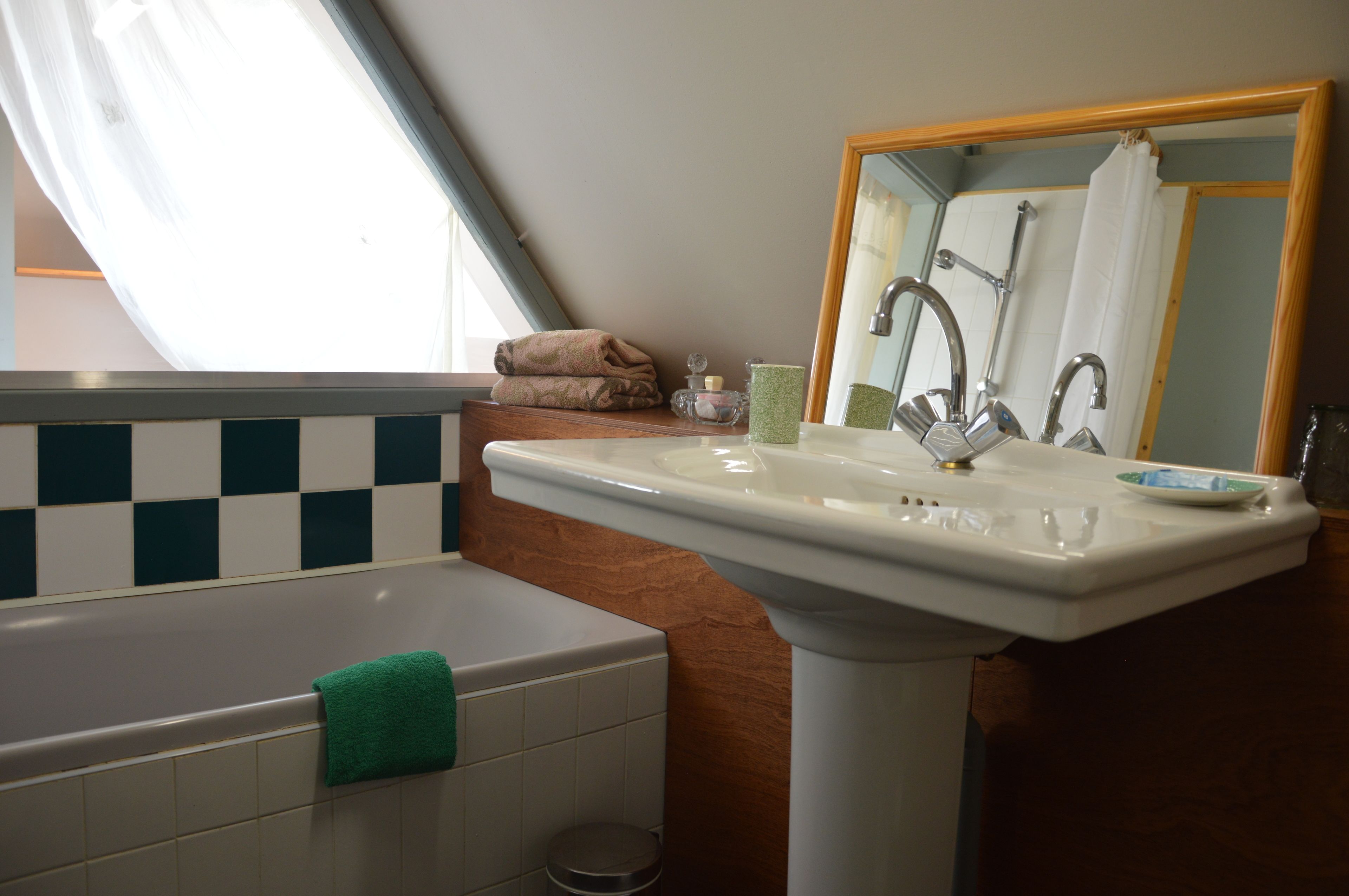 Een badkamer met een bad, een wastafel en een spiegel.