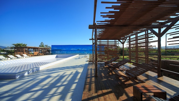 A wooden deck with lounge chairs and a pool area overlooking the ocean. - Wild Island B&B (Hengchun)