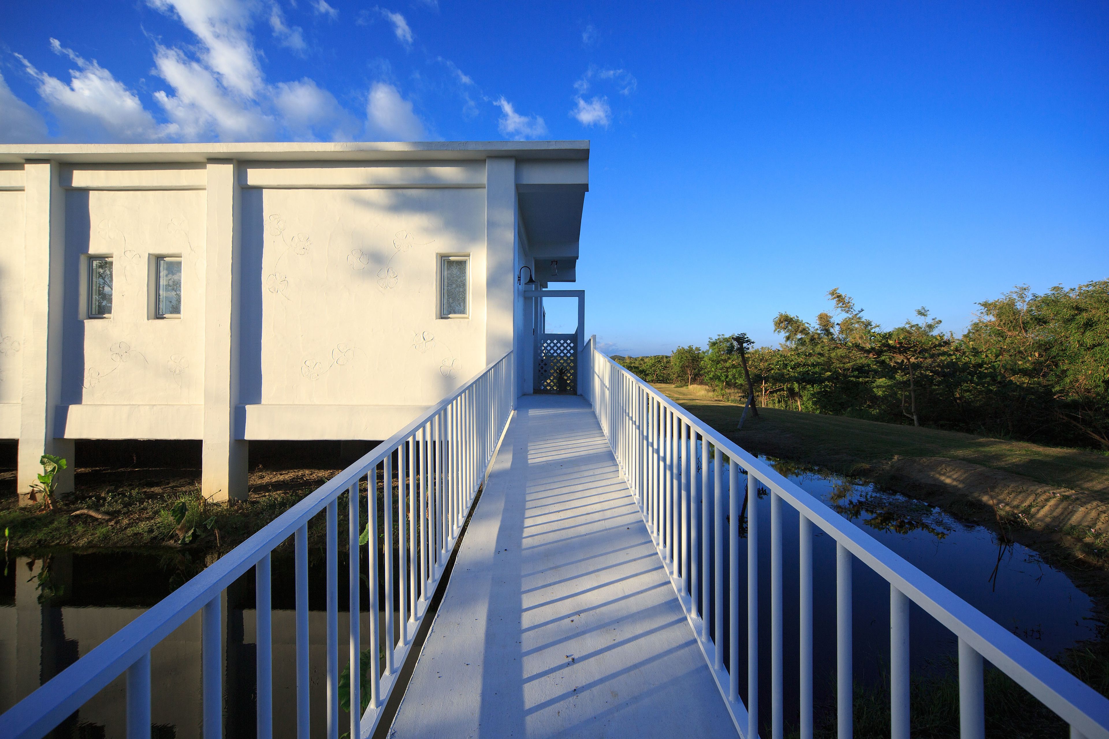 A white building with a covered walkway leading to a door.