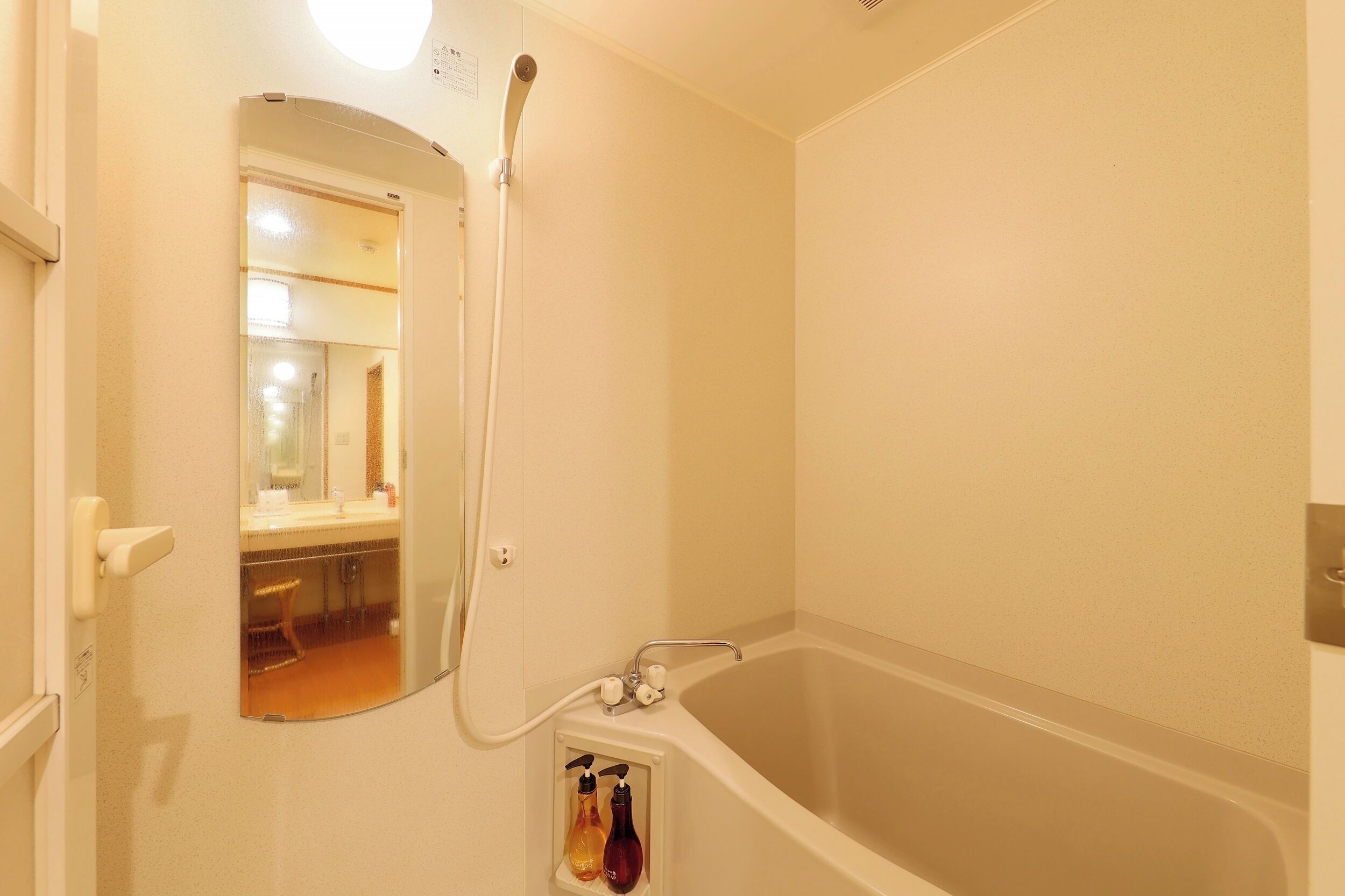Un baño con bañera, ducha y espejo.