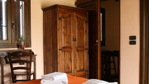 A room with a bed, wooden wardrobe, and a desk with a chair. - Vento di Maremma (Grosseto)