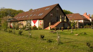 Il s’agit d’un bâtiment traditionnel en pierre, doté d’un toit en pente, d’un escalier menant à l’entrée et d’une pelouse bien entretenue.