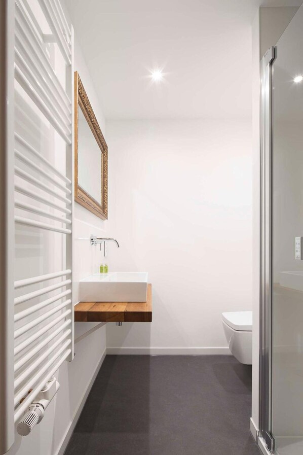 A modern bathroom with a white vanity, a glass shower enclosure, and a white toilet. - Moselhotel Restaurant Peifer (Brodenbach)