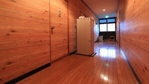 Ein Korridor mit Holzwänden und einem Kühlschrank.