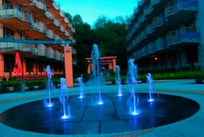 A building with multiple balconies and a central fountain.