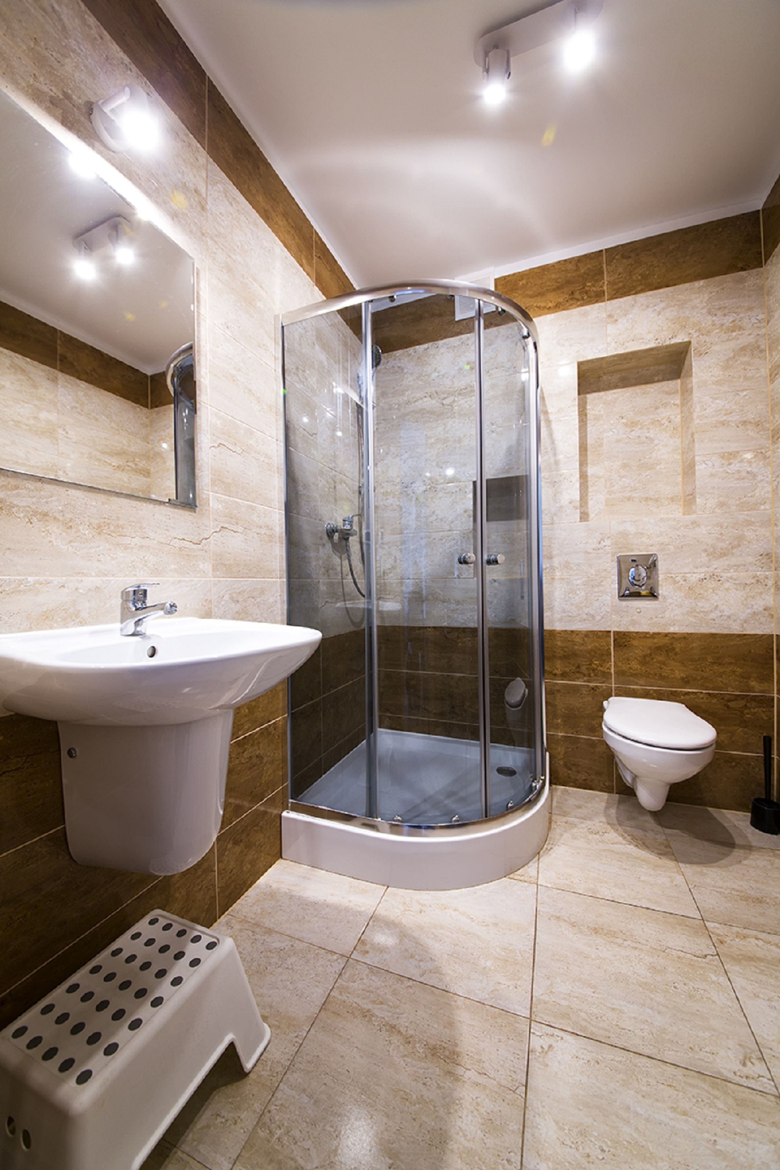 Ein modernes Badezimmer mit einer Duschkabine, einem Standwaschbecken und einer Toilette.