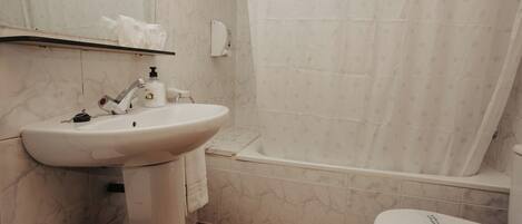 A bathroom with a sink, toilet, and bathtub.