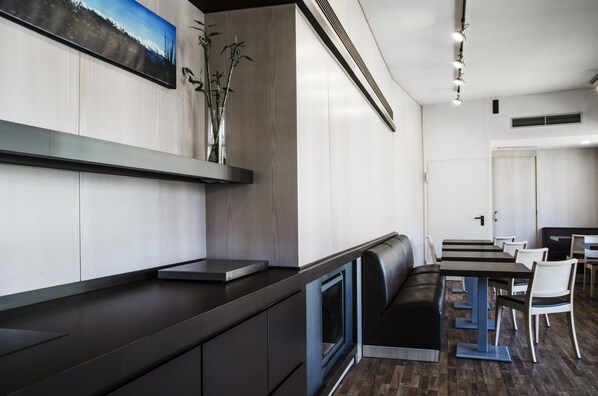 A modern restaurant with a long counter, seating area, and a wall-mounted picture. - La Trobada Hotel Sport (Ripoll)