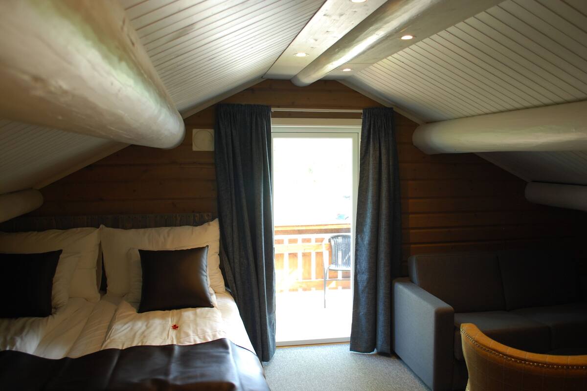 Ein gemütliches Schlafzimmer mit Bett, Stuhl und Balkon.