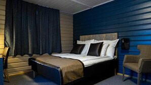 Une chambre à coucher avec un lit, une chaise, un bureau et une lampe.