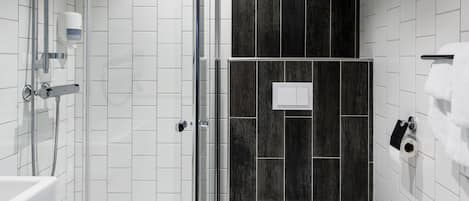 A modern bathroom with a glass-enclosed shower, a white toilet, and a towel rack.