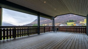 Une terrasse en bois offrant une vue sur un paysage montagneux.