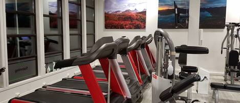 A gym with treadmills, weight machines, and exercise equipment.