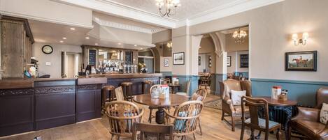 A spacious dining area with wooden furniture and a central round table.