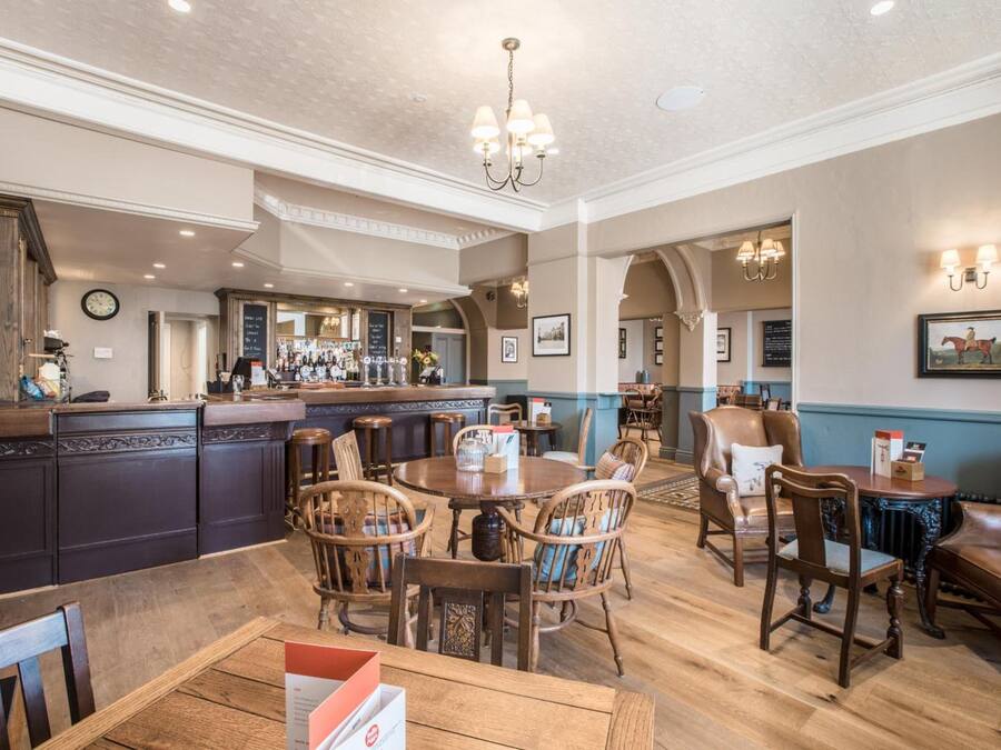 A spacious dining area with wooden furniture and a central round table.