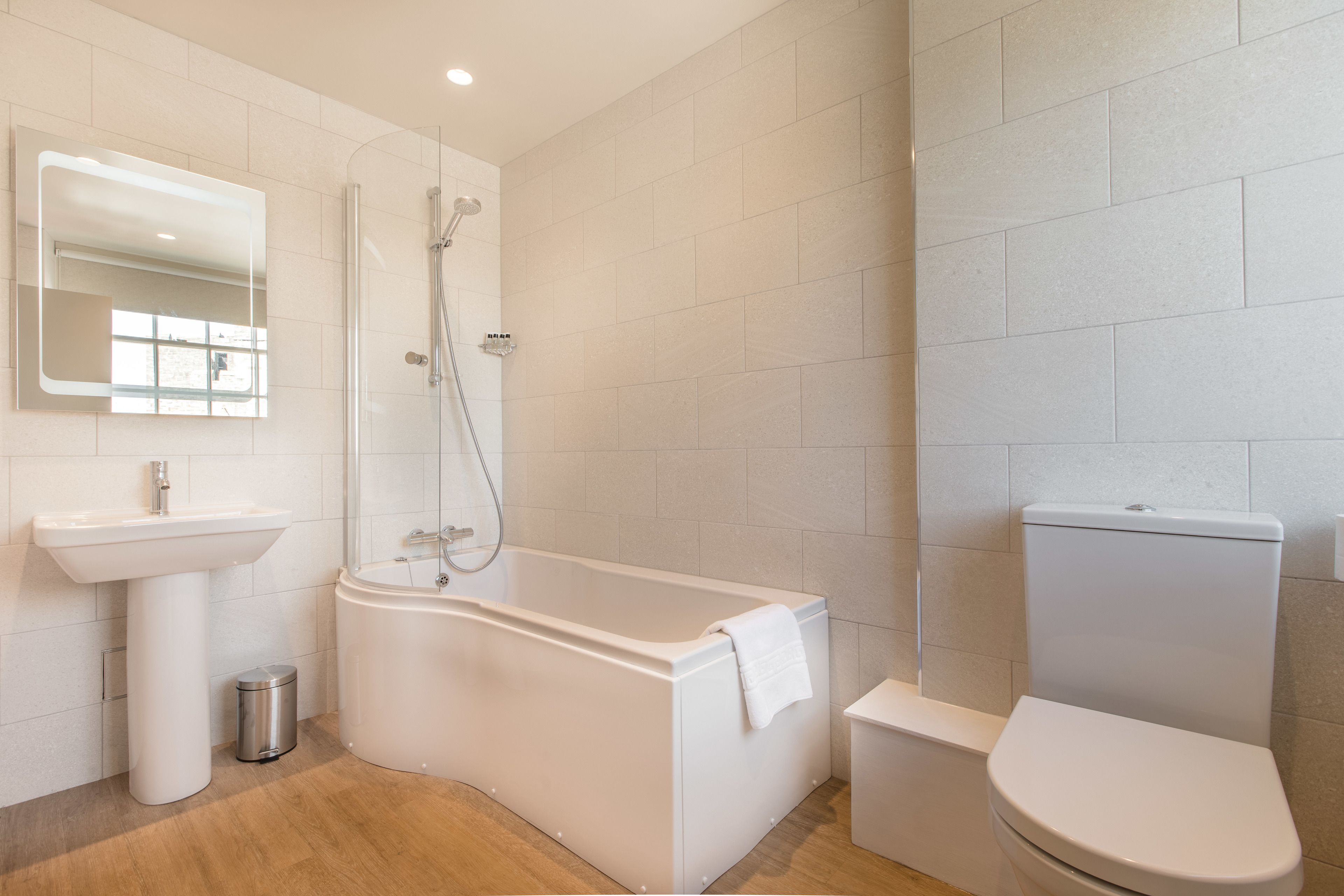 A modern bathroom with a freestanding bathtub, a sink, and a toilet.