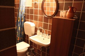 Une salle de bain avec des toilettes, un lavabo et un miroir.