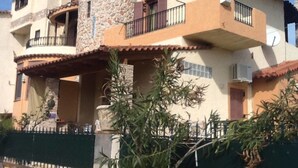 A multi-story building with a stone facade, balconies, and a gated entrance. - Petrospito Pool Apt ''Katoi'', Faros Avlida (Chalcis)