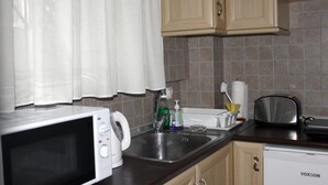 Appartement | Cuisinette priv ée | Réfrigérateur, four à micro-ondes, vaisselle et ustensiles