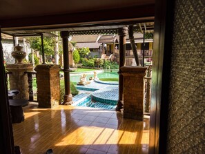 A view of a courtyard with a swimming pool, stone columns, and a tiled floor. - Grand Orchid Resort (Ko Chang)