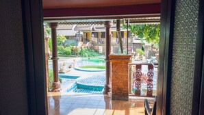 A view of a courtyard with a swimming pool, surrounded by traditional architecture and greenery. - Grand Orchid Resort (Ko Chang)