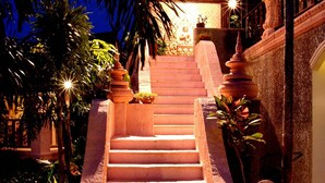 A staircase with a statue at each end, leading to a building entrance. - Grand Orchid Resort (Ko Chang)