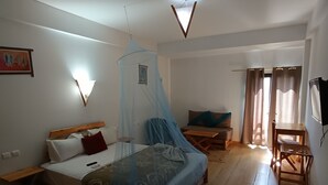 A bedroom with a bed, bedside table, chair, and a small desk with a chair. - Green Cactus (Ben Guerir)
