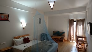 Un dormitorio con una cama, mesita de noche y un escritorio pequeño con una silla.