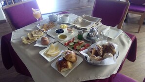 Una mesa de desayuno con diversas comidas y una taza de café.