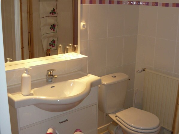 A bathroom with a white sink, mirror, and toilet. There is a bottle of soap on the sink and a towel rack above it. - La Coutrotte Becquine (Heuilley-sur-Saone)