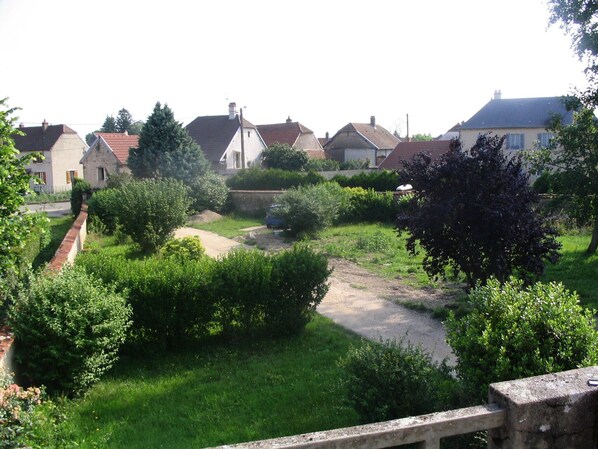 A residential area with houses, a dirt path, and greenery.