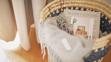 A wicker basket with a book titled "MADE for LIVING" and a grey fabric item.