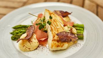 En tallerken med grillet fisk, asparges og en cremet sauce.