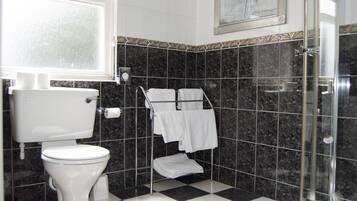 A bathroom with a toilet, a shower, and a sink.