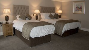 A double bed with a tufted headboard, two bedside tables with lamps, and a framed picture on the wall. - The Ryandale Inn (Dungannon)