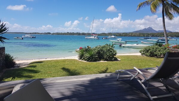 Rannalla, valkoista hiekkaa, aurinkotuoleja, rantapyyhkeitä