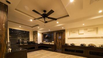 A modern kitchen with a central island, built-in appliances, and a ceiling fan.
