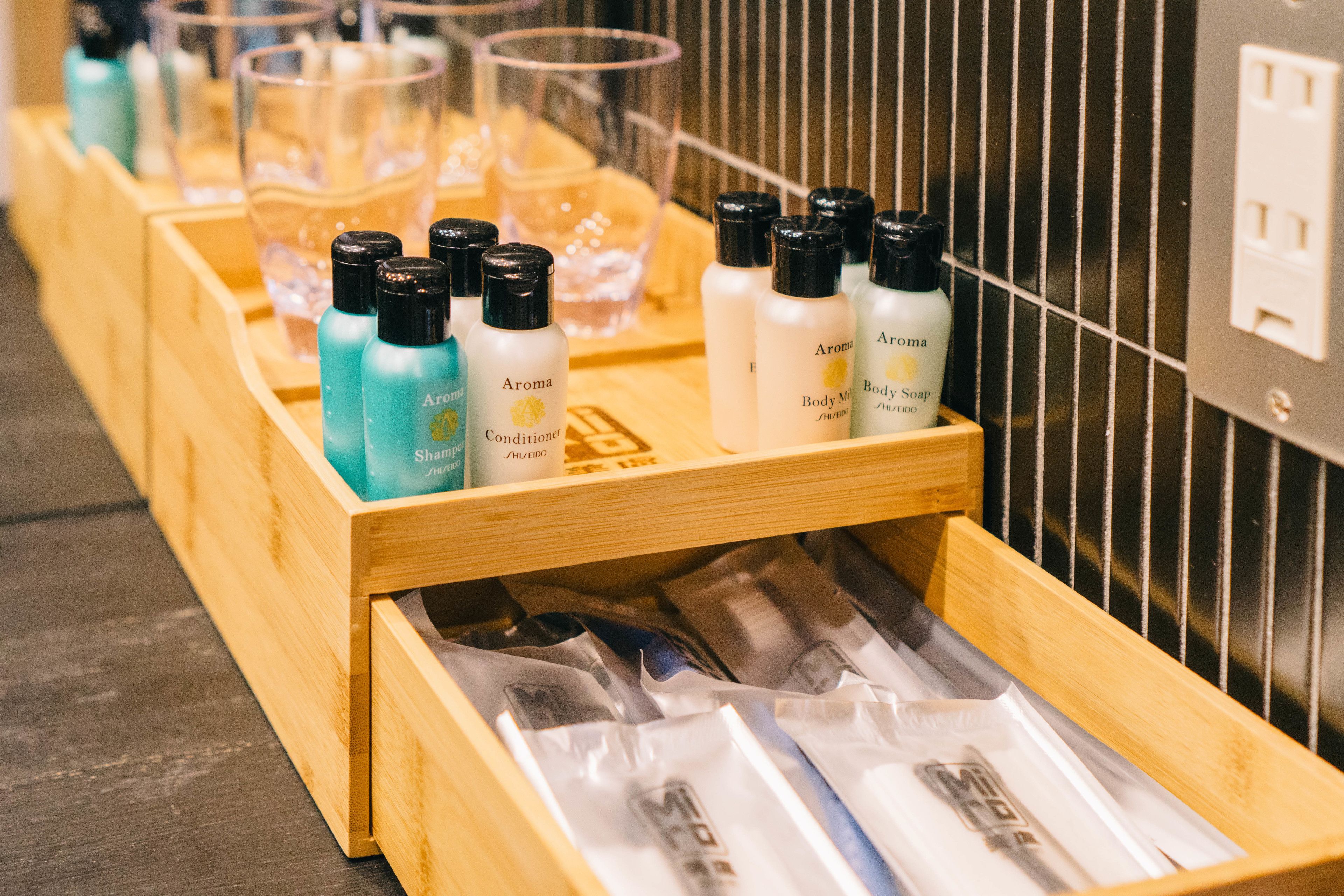 A wooden display with various toiletries including bottles of body wash and conditioner.