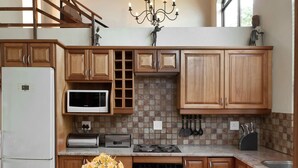 A kitchen with wooden cabinets, a microwave, a toaster, a stove, and a sink.