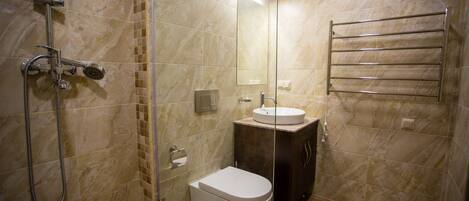 A modern bathroom with a glass-enclosed shower, a white toilet, and a vanity with a sink.