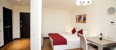Un dormitorio con una cama, una mesa de comedor y una silla.