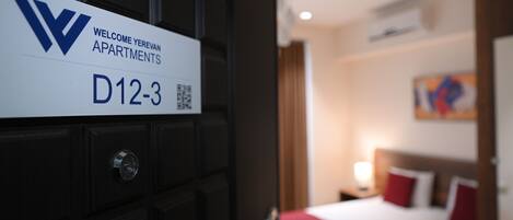 Entrada a un cuarto de hotel con un letrero que dice 'Welcome Yerevan Apartments D12-3'.