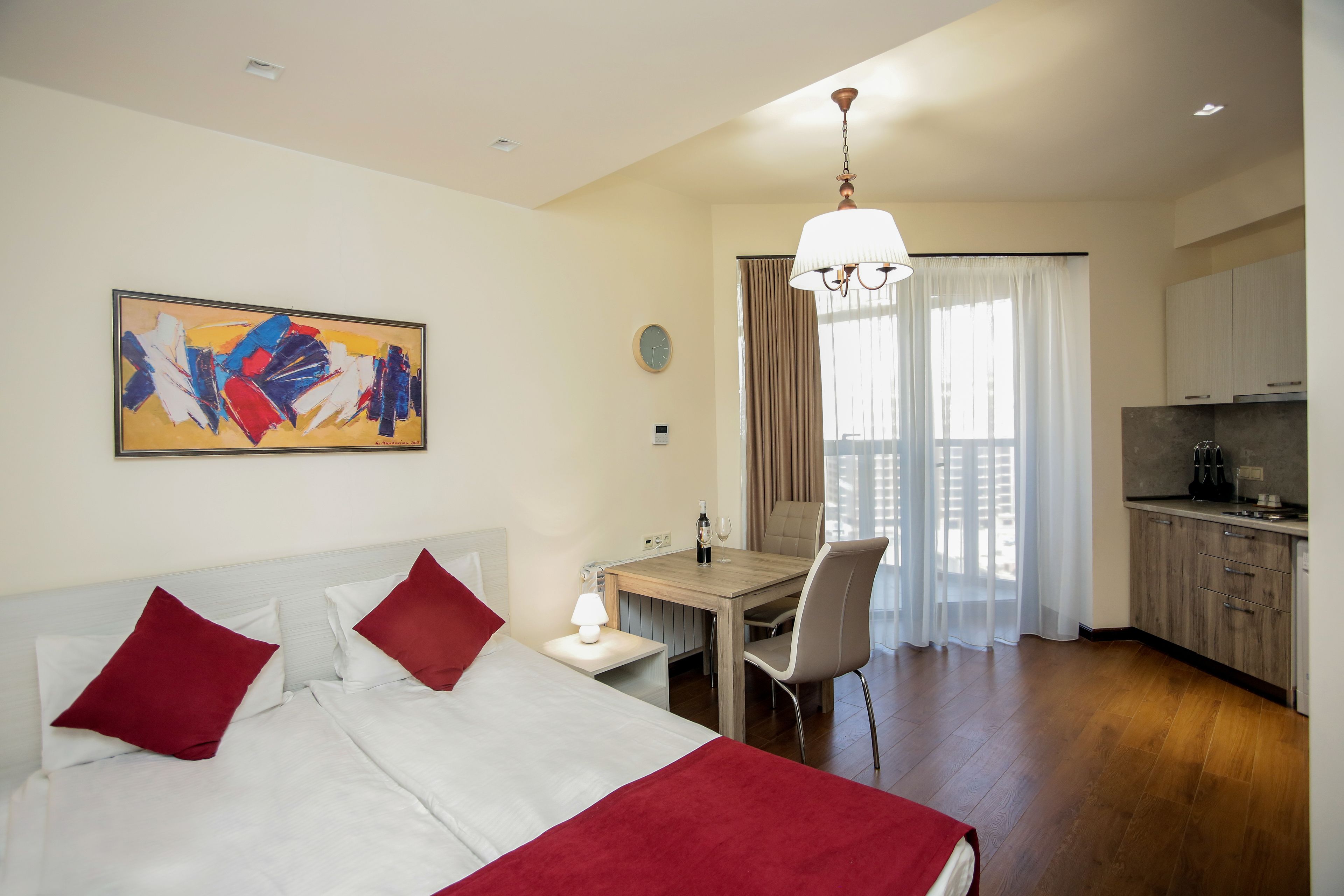 Une chambre d’hôtel comprenant un lit, un bureau, une chaise, un coin repas et une cuisine.