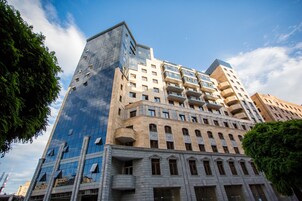 A multi-story building with a mix of modern and classical architectural styles, featuring balconies and large windows.