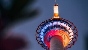 A tall tower with a circular observation deck at the top, illuminated with red and blue lights. - Miro Saiinnishi Imadacho Tei (Kyoto)