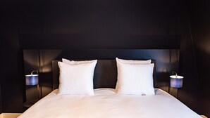 A neatly made bed with white linens and pillows, flanked by two wall-mounted lamps. - Boutique Hotel Zaan (Zaandijk)