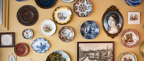 A collection of various plates and framed pictures on a wall.